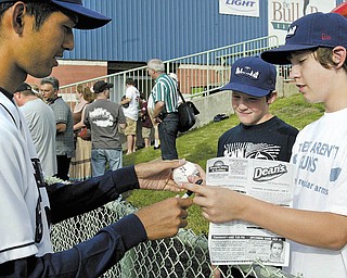 Before the start of Monday’s home-opener game at Eastwood Field in Niles, Mahoning Valley Scrappers player
Takafumi Nakamura, left, signs a baseball ball for fans Joe Homa, 11, center, and Tyler Longwell, 13, both of Warren. The Scrappers opened their 11th season as a Minor League affi liate of the Cleveland Indians.