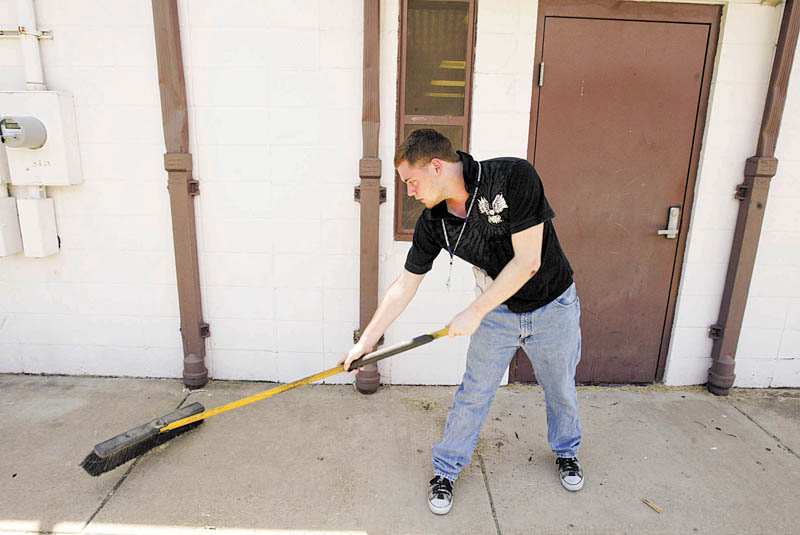 Dante Dutch, 17, helps in Monday’s cleanup near Neighborhood Ministries in Campbell. 
