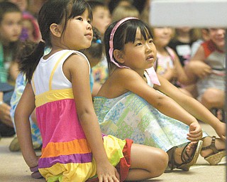 Best friends Emily Choleva, 5, and Kira Vasko, 5, both of Boardman, sit rapt with attention at the summer program at the Boardman Library.