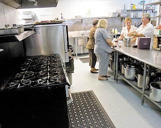 Volunteers prepare refreshments in the newly remodeled kitchen at the St. Vincent De Paul Society Dining Hall. The facility, which serves meals to people in need, just completed a renovation.