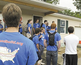 Monica Craven, far right, executive director of Mahoning County Habitat for Humanity, gives instructions to a group of 30 cyclists from Bike & Build, a nonprofit organization that helps build affordable housing as it travels a cycling route. The group pitched in at a Habitat house on Maranatha Drive in Youngstown.