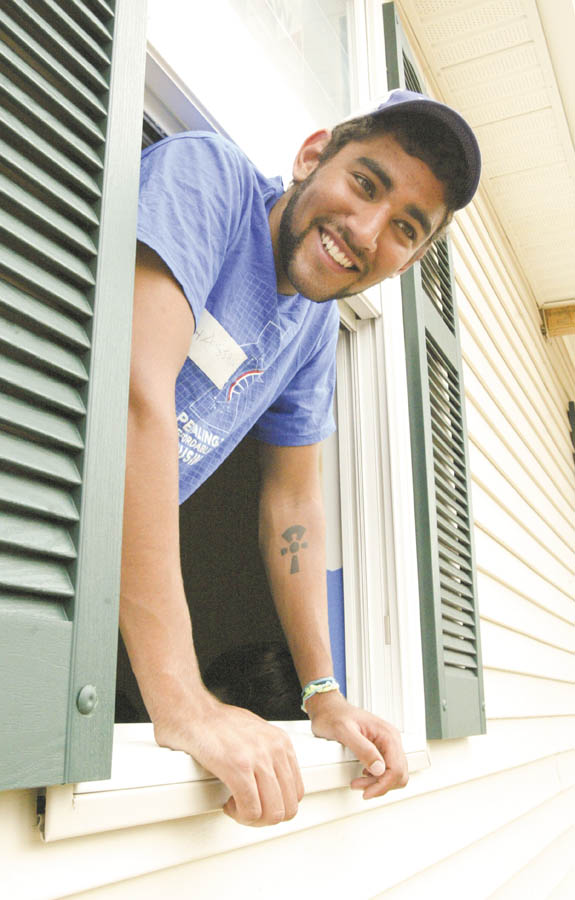 Bike & Build volunteer Hassam Shalla of Philadelphia checks out a window at the Mahoning County Habitat for Humanity house under construction on Maranatha Drive in Youngstown.