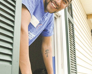 Bike & Build volunteer Hassam Shalla of Philadelphia checks out a window at the Mahoning County Habitat for Humanity house under construction on Maranatha Drive in Youngstown.