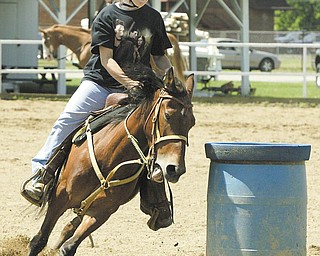 Mariah McGeehen, 13, of Newton Falls, is a picture of concentration as she guides her horse, Starr, around a barrel in preparation for 4-H competition at the Trumbull County Fair. Fair officials said the number of 4-H participants is up for this year’s events.