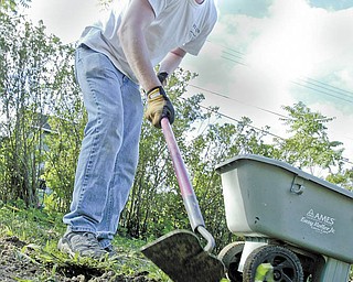 Sandy Wilson with Lien Forward Ohio prepares the ground for planting grass and trees at the corner of Oakland Avenue and Columbia Street in Youngstown’s Brier Hill district. Lien Forward and V&M Star organized a group of about 30 volunteers to spruce up the vacant lot Wednesday.