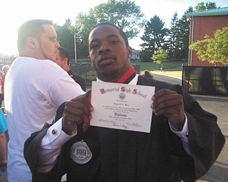 Reginald Jermaine Isiah Ware shows off his diploma following graduation from Campbell Memorial High School.