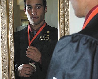 Anthony Pannunzio of Mineral Ridge High School puts his valedictorian medal on before heading to the graduation ceremony.