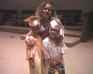 Big sister Delia Walkowiec, 9, congratulates brother Zenin, and classmate Maria Slaton, 5, of Austintown at preschool graduation from For Kids Sake.