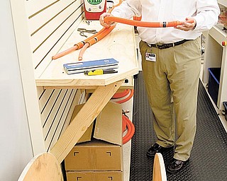 Randy Sumner, Dephi’s director of global hybrid- vehicle development for the electrical/electronic architecture division, shows the orange wire signifying the high voltage required for engine-power supply in hybrid vehicles.