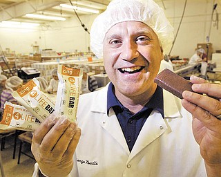 George Tsudis, owner of Belmont Confections in Liberty, shows off his new creation, a gluten-free energy bar with 40 antioxidants that he says provides a 100 percent dose of daily fruits, vegetables and vitamins. The bar went on sale Tuesday at GNC stores.