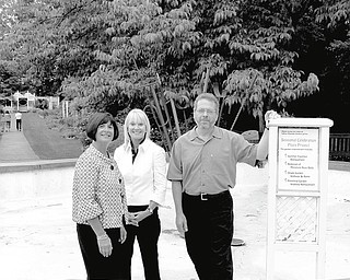 In no danger of getting their feet wet as they stand in the basin of the old K. Calvin Sommer Fountain in Fellows Riverside Gardens, where a new fountain will be built are, from left, Sharon Letson, garden party chairwoman; Pati Opalka, co-chairwoman, and Keith Kaiser, horticulture director at Mill Creek MetroParks.