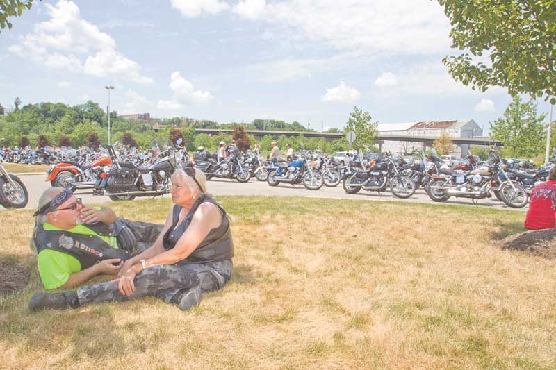 Gary Mathews of Ellsworth, a member of the Blue Knights of Ohio, and Patty Cleburn of Columbiana relax on the grass as they await the start of the eighth annual memorial motorcycle run. The Blue Knights co-sponsored the run.