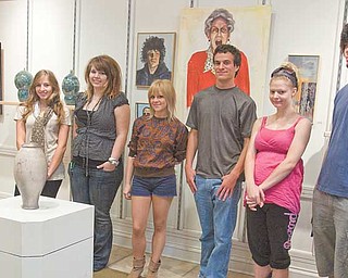 Artists, left to right, Nikki Mehle of Canfield, Hailey Snow of Youngstown, Valerie Nichols of Austintown, Ben Belgrad of Boardman, Jessica Grizinski of Boardman and Justin Reese of Youngstown stand with their artwork displayed at the Art Outreach Gallery.