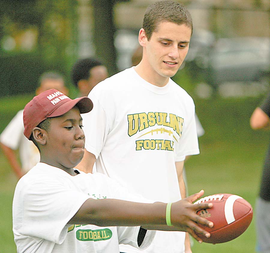 Matthew Taylor 12, of Austintown gets some pointers from the class of 2008 kicke Michael Metzinger at the Ursuline High School Footbal Camp.