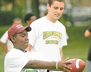 Matthew Taylor 12, of Austintown gets some pointers from the class of 2008 kicke Michael Metzinger at the Ursuline High School Footbal Camp.