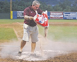 Greg Krieger works on the field during the rain delay Wednesday niight.