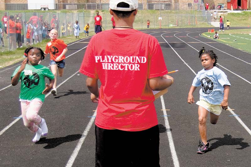 Under the watchful eye of a playground director, Leah Harris, 6, left, and Jalaya Brown, right, both of Youngstown, race to the finish line in the 50-meter dash at the Youngstown Park and Recreation Department’s annual track and field day at Cardinal Mooney High School. Behind Leah is Ana’Lyse Cole, 7, of Struthers. The unidentified director recorded the order of finish Thursday. 