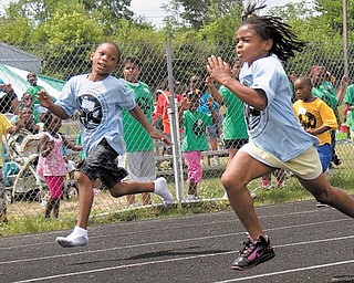Kevon Weaver, 7, left, of Youngstown, goes shoeless in his race with Jalaya in the 50-meter dash. The children in the park department’s summer day-camp program were able compete in various track and field events. 