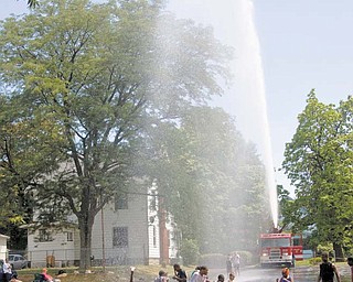 Above left, a firetruck from Youngstown Fire Station 2 provides a water spray for participants in the summer camp Thursday at Martin Luther Lutheran Church, 420 Clearmount Drive, Youngstown. Among activities this week for the children age 6 to 15 were Bible stories, music and crafts.