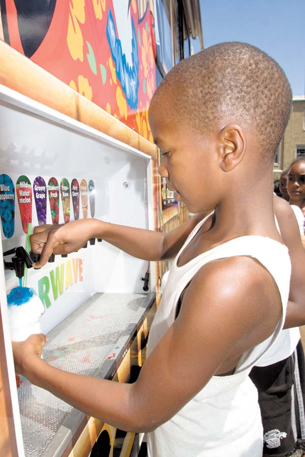Darrell Jackson, 8, of Youngstown tries the blue raspberry flavoring on a sno-cone from Tim Oswald’s Kona Ice, which provided a cool treat for campers.