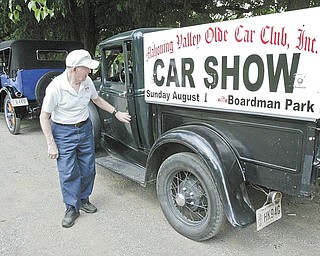 Joe Bush gets out of his 1931 Model A Ford truck, which carries the placard for the Mahoning Valley Olde Car Club car show Sunday in Boardman Park. Bush is a club member.
