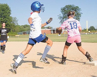 Abby Masluk, center, makes her way to fi rst base, as Maddie Rowe, left, throws to Aleah Hughes during Poland’s 11-12 Little League softball practice on Tuesday.