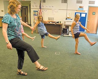 Julie Macomber , a volunteer at Hubbard Public Library, leads a dance lesson on the Cupid Shuffle line dance. In step are, from left, Chelsea Murphy, 8, partially obscured; Celeste Wilbois, 11; and Gabriella Torok, 9, all of Hubbard. Another dance lesson is planned next week.