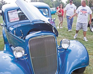 Marlene and Larry Clark of Canfield and Jim Bradick of Youngstown, check out Jerry Kolesar's 1935 Chevy at Boardman Park for the Mahoning Valley Olde Car Club car show.