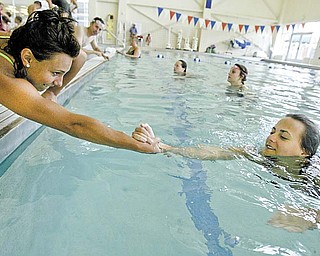 Carle Tofil, 16, left, of Struthers and Margo Ucchino, 18, of Poland practice rescue techniques during a lifeguard-training class at the D.D. & Velma Davis YMCA in Boardman.