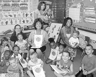 Letting them know: They’re worth it: Mariellen Rich, center, recently presented 30 copies of “You Are Worth the World” books to the children at Easter Seals, along with a poster. Rich is a member of Angels of Easter Seals. You Are Worth the World is a project that helps local children at Casa Madre, in Kenya and at the National Institutes of Health in Bethesda, Md., who are affected by HIV/AIDS. Casa Madre is a respite house run by the Ursuline Sisters for kids with HIV or AIDS. The book is meant to inspire the children to realize their importance in the world and the awareness of the beauty around them. Children from Easter Seals, Kenya and the NIHA illustrated the book. For a new book by Rich, “Freckles the Fabulous Fish,” the children of Easter Seals are doing the illustrations. On Rich’s right is Amanda Auriemma, Easter Seals staff member, on her left is staff member Pam Rainey, and behind Rich is staff member Heather Cominsky.