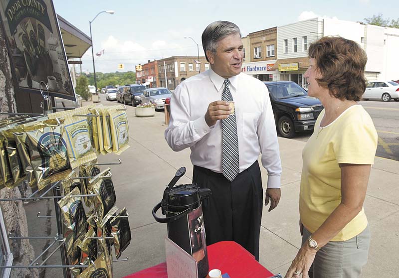 Girard Mayor James Melfi samples a specialty coffee as he chats with Peggy Magill, owner of Cards Candles and Collectibles on West Liberty Street in Girard. The mayor said specialty stores in the city have filled a niche and are weathering a tough economy. 