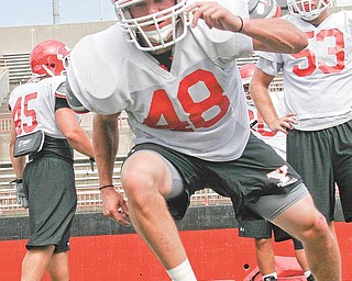 YSU sophomore linebacker Ethan Slark stays low during a drill at Wednesday’s practice at Stambaugh Stadium.