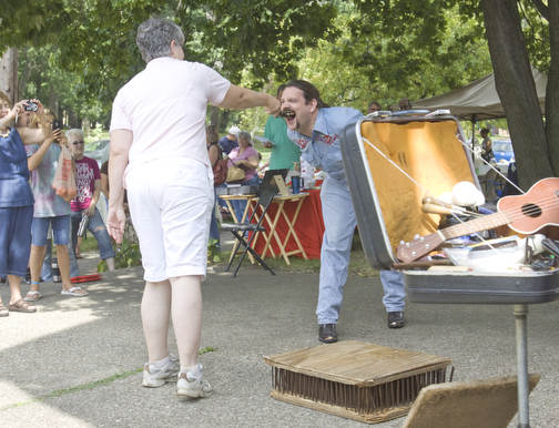 LISA-ANN ISHIHARA | THE VINDICATOR..A volunteer pulls a swore out of Travis' mouth during his teaser performance at Northside Farmers Market for upcoming events in Youngstown. He is one half of "The Pickled Brothers."