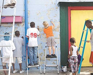 Young neighborhood volunteers scrape chipped paint and brush on fresh paint to the side of the former Sparkle Market at 2410 Glenwood Ave., Youngstown. James London, president of Idora Neighborhood Association, said the group received a $2,000 grant from the Wean Foundation for this project. He credits his granddaughter, Sierra Hopson, 6, for the mural drawing. The effort also included volunteers from Art Youngstown Inc. and Goodness Grows.