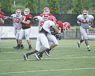 Defender Brandian Ross, left, tackles Jamaine Cook during a recent Youngstown State University scrimmage. Ross is one of the Penguins’ team captains for 2010.
