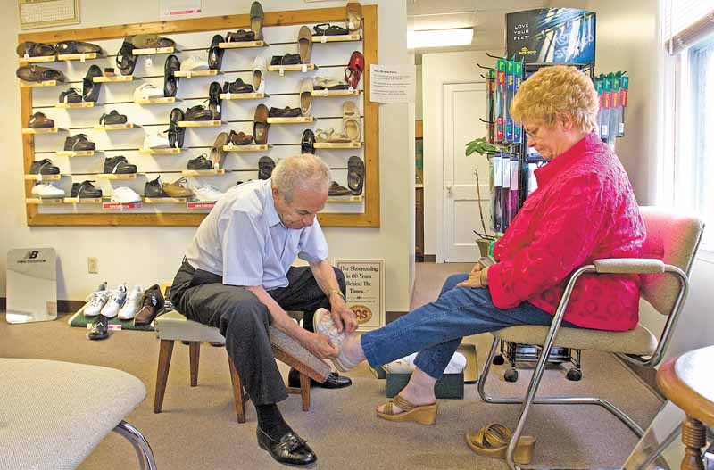 Joe Marzano, of Youngstown's South Side, helps Myra McClain, of Canfield, try on a pair of shoes at Diorio Shoes in Poland on Wednesday afternoon.