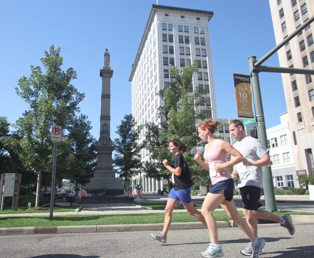 LESLIE CUSANO | THE VINDICATOR.Participants in the Panerathon run past the Man on the Monument in Downtown Youngstown. All money raised from the event will help build the Joanie Abdu Comprehensive Breast Care Center.