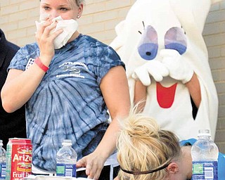 Alyssa Koval of North Jackson holds a napkin over her mouth as she recovers from downing 11 pirogis in a pirogi-eating contest during Polish Day. Her cousin, Ashley Koval of Youngstown, rests her head on the table after taking second place by eating 14 pirogis in three minutes.