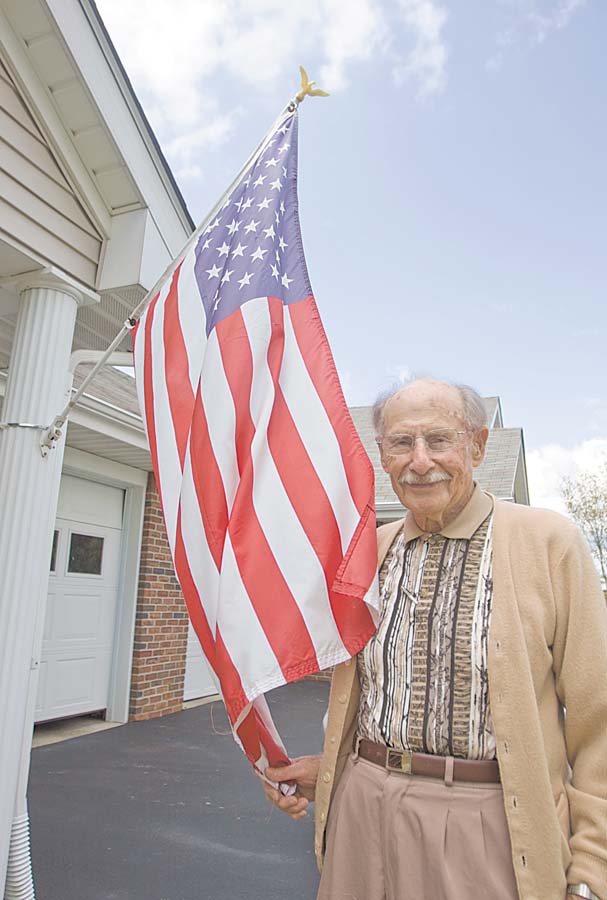 Ray Braidich, a World War II veteran, stands by the American flag mounted outside his home at Shepherd of the Valley-Poland. Braidich thinks there should be a more-dignified vessel in which to burn worn flags, noting that a trash can or burn barrel is often used in flag-disposal ceremonies.