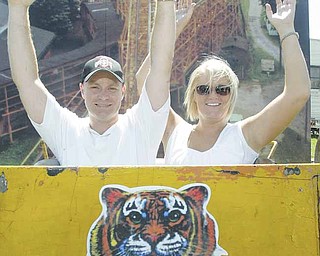 George Summers and Melanie Smith pose in a Wildcat roller-coaster car from Idora Park on display at the Canfield Fair. Smith’s father, Robert Karzmer of Youngstown, found the 1,000-pound original coaster car in a local body shop.