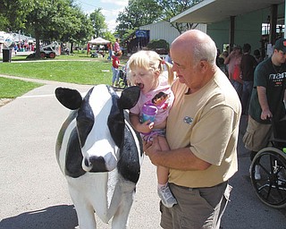 Lindsey, of Detroit, Mich., and Fred of Struthers visit the cow statue by the milking booth. Photo submitted by Danielle Springer of Detroit, Mich.