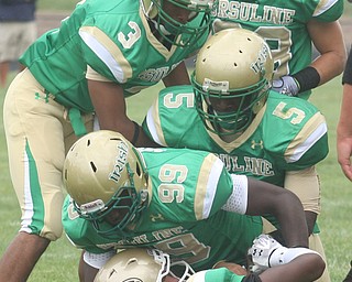 URSULINE - Quarterback Luke Petro is buried under the Ursuline defense (25) Tramain Thigpen, (99) Khallid Pierce, (5) Jesse Curry (3) Kevin Cylar and (33) Jeff Podolsky Saturday afternoon. - Special to The Vindicator/Nick Mays