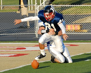 Warren JFK punter #21 Mark Fordeley and Hubbard rusher #9 Taylor Karabin battle for the loose ball after the snap went over Fordeley's head. The ball would be kicked out of the back of the endzone by a JFK player for the saftey.