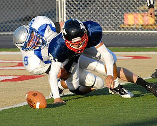 Warren JFK punter #21 Mark Fordeley and Hubbard rusher #9 Taylor Karabin battle for the loose ball after the snap went over Fordeley's head. The ball would be kicked out of the back of the endzone by a JFK player for the saftey.