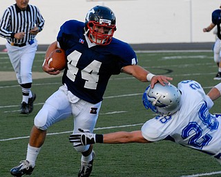 Warren JFK running back #44 James Coates stiff arms the Hubbard tackler #28 Kory Hopkinson.