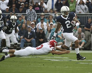 ROBERT K. YOSAY | THE VINDICATOR..SLIPPIN away - PSU #2 Chaz Powell almost gets taken down by YSU #13 Stephen Blose as PSU runs back a kickoff to put PSU in the lead.YSU LOSES 44-14 PENN STATE at BEAVER STADIUM IN HAPPY VALLEY.-30
