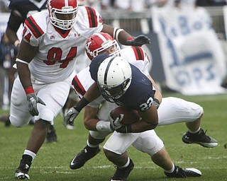ROBERT K. YOSAY | THE VINDICATOR..Bringing him down is YSU #26 David Rach as he stops PSU #22 Evan Royster - behind them is #94 YSU Torrance Nicholson.YSU LOSES 44-14 PENN STATE at BEAVER STADIUM IN HAPPY VALLEY.-30