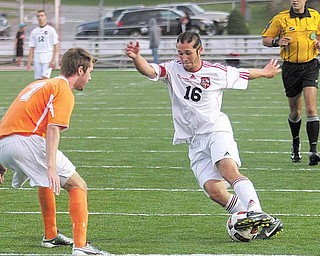 Canfield’s Patrick Stickle (16) tries to maneuver around Howland’s Scott Heinemann (7) during a soccer
game Thursday in Canfield. The Cardinals defeated the Tigers, 3-0, with Stickle scoring two goals.