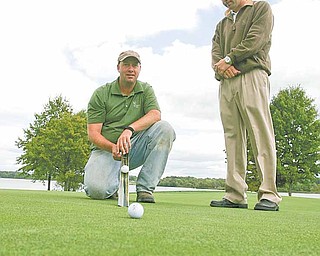 Mike Ferranti, right, golf pro at The Lake Club in Poland, watches Thursday as course superintendent Chris Brown
uses a stimpmeter to check the roll on a green. The two have spent the past several weeks making sure every blade of grass and every grain of sand on the course is up to par for the championship round of the “Greatest Golfer of the Valley” tournament on Sept. 18. Opening play is Saturday at Mill Creek and Sunday at Trumbull Country Club.