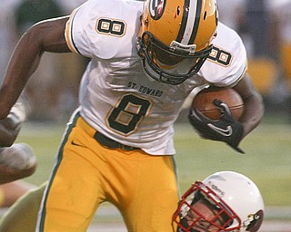 ROBERT K. YOSAY | THE VINDICATOR..Taking it on the chin is #24 CM Joe DiNiro as St Eds #8 Quincy Jones breaks the tackle Cardinal Mooney vs St. Ed's at Fitch Stadium..-30